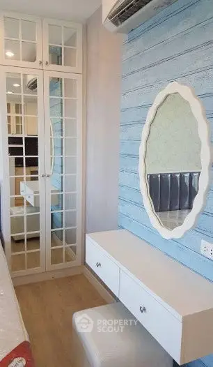 Chic bedroom corner with mirrored wardrobe and stylish vanity in modern apartment.