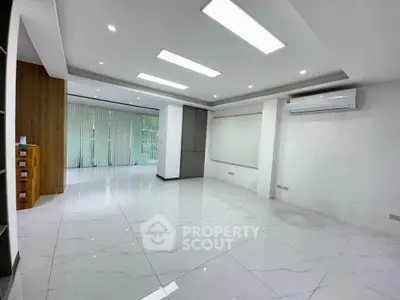 Spacious modern living room with sleek tile flooring and large windows.