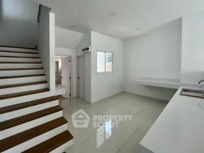 Modern minimalist interior with sleek staircase and open layout kitchen