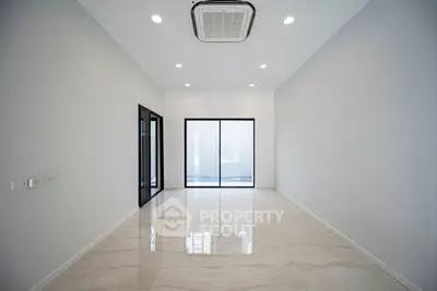 Spacious modern room with sleek design and large windows, perfect for versatile living space.