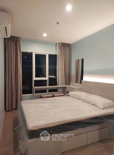 Modern bedroom with large window and stylish decor in high-rise apartment.