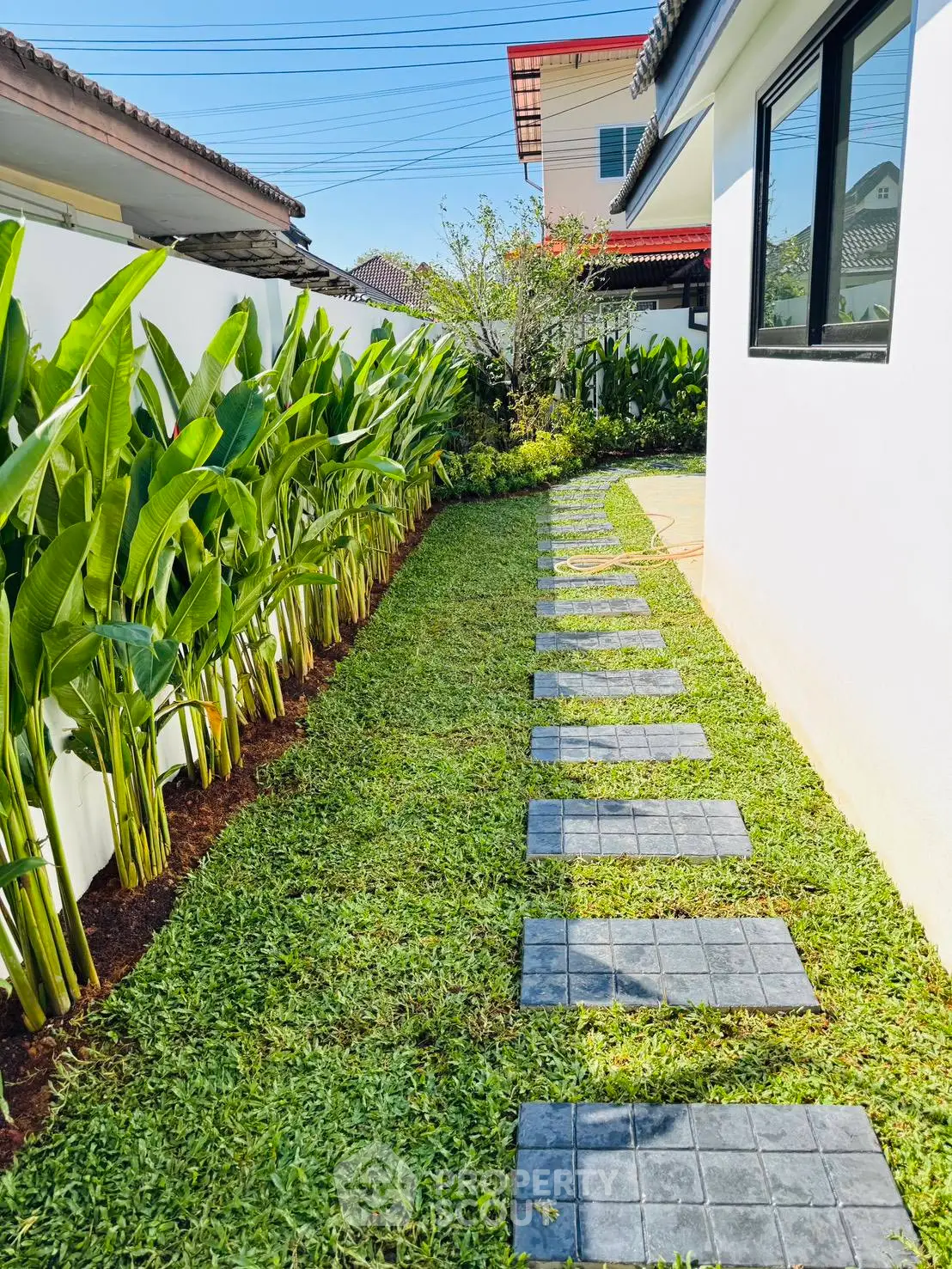 Charming garden pathway with lush greenery and modern design in a residential property.