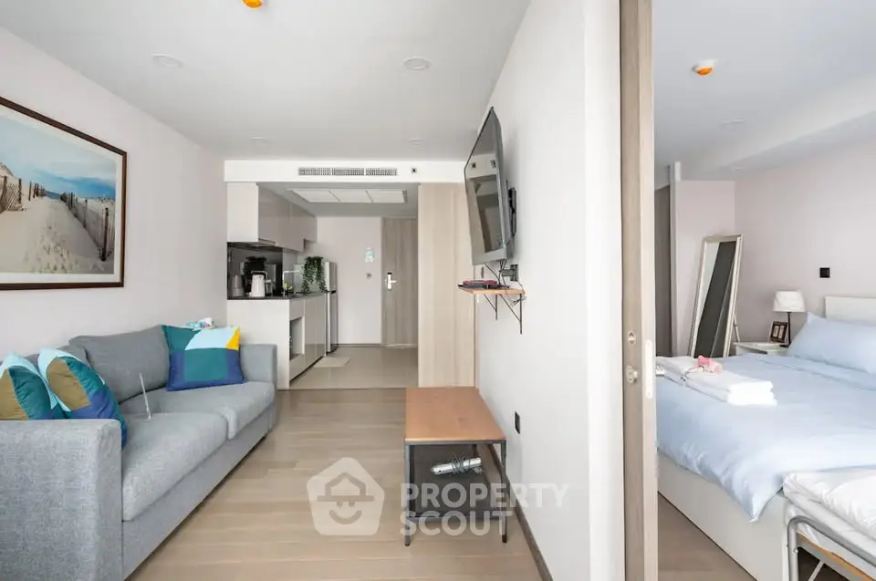 Modern open-plan living room and bedroom with stylish decor and natural light.