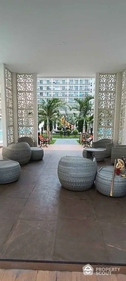 Luxurious outdoor seating area with modern furniture and palm trees in a high-end residential complex.