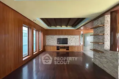 Spacious living room with wooden paneling and modern entertainment center