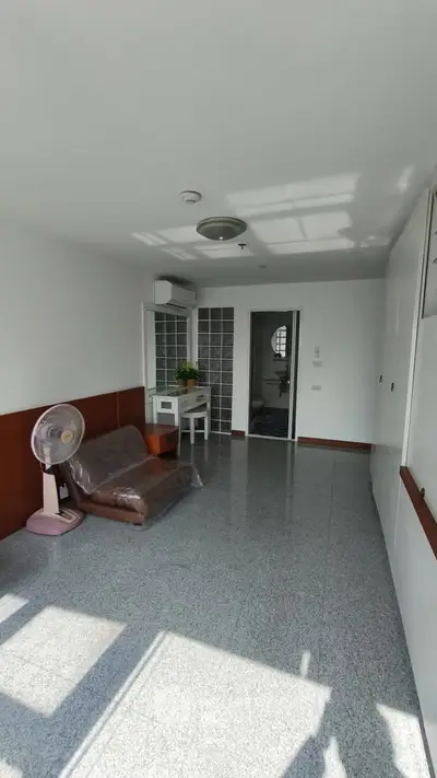 Bright living room with tiled floor, air conditioning, and natural light.