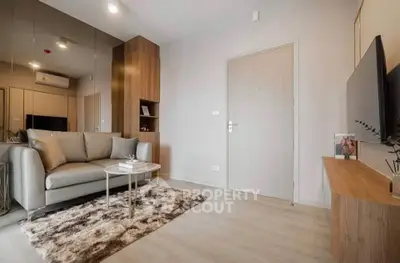 Modern living room with stylish decor and cozy ambiance, featuring a plush sofa and sleek TV setup.