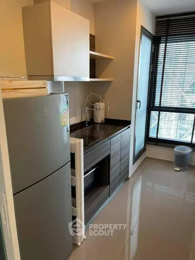 Modern kitchen with sleek cabinetry and large window offering natural light.