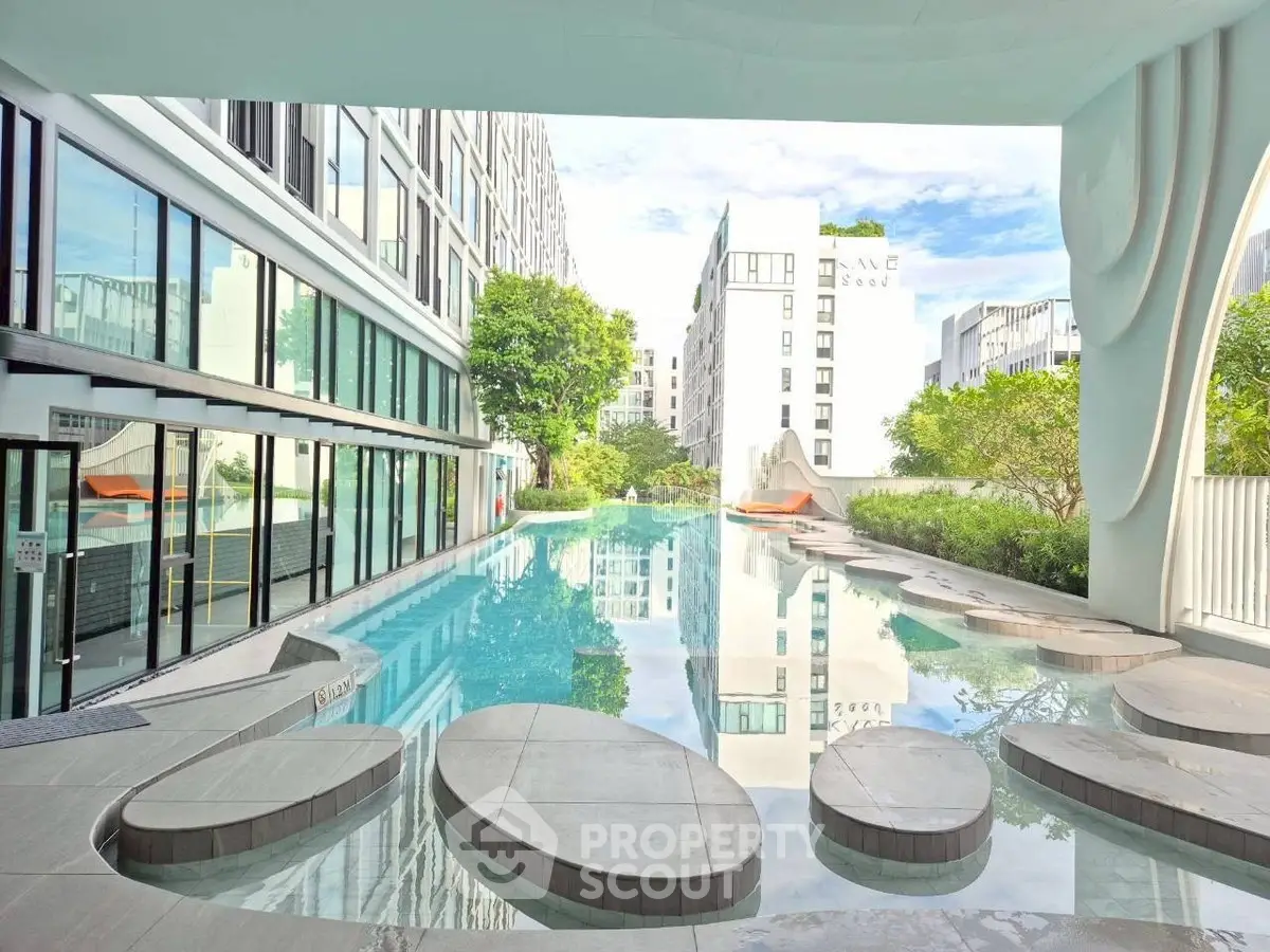 Luxurious modern apartment complex with stunning pool and architectural design.