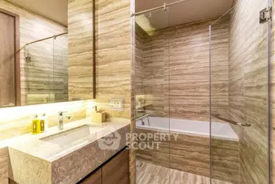 Luxurious modern bathroom with marble finishes and glass shower enclosure