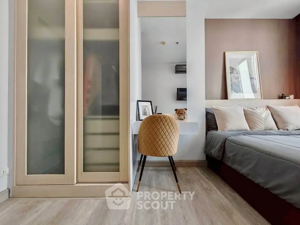 Modern bedroom with stylish decor and workspace, featuring a cozy bed and sleek wardrobe.