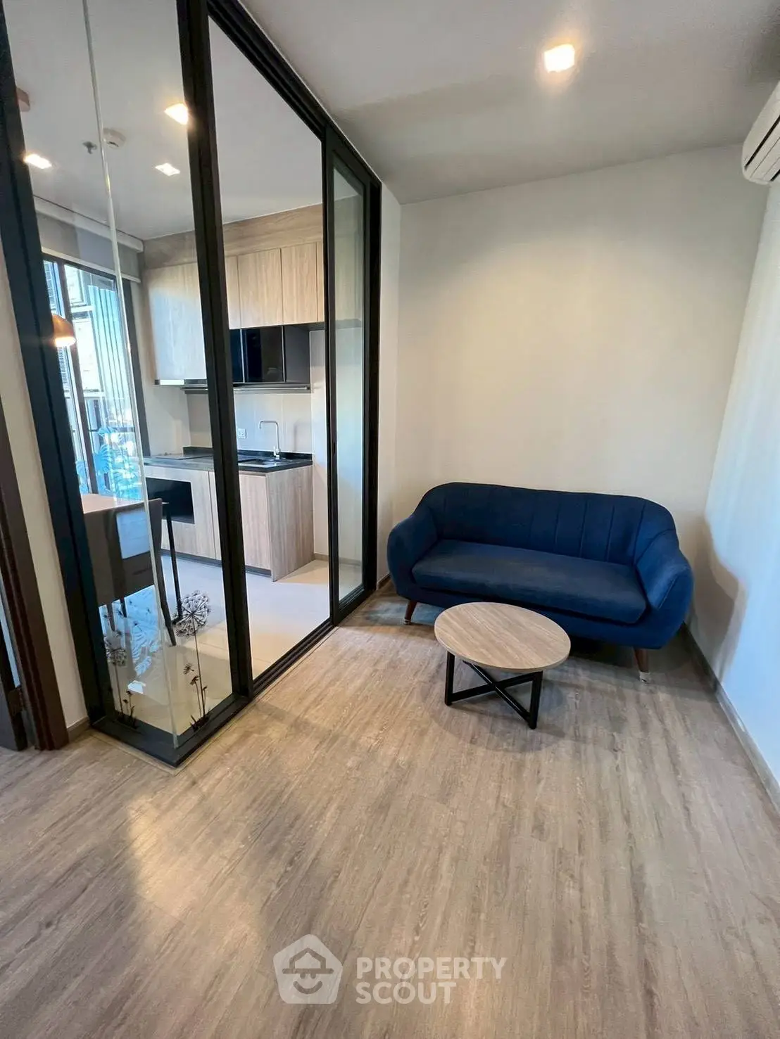 Modern living room with blue sofa and open kitchen layout