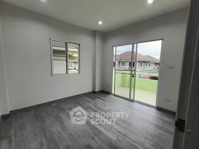 Spacious modern room with balcony and large windows in a suburban home.