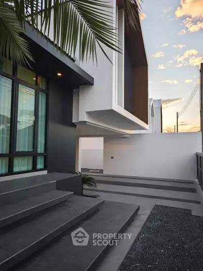 Modern architectural exterior with sleek design and large windows at sunset