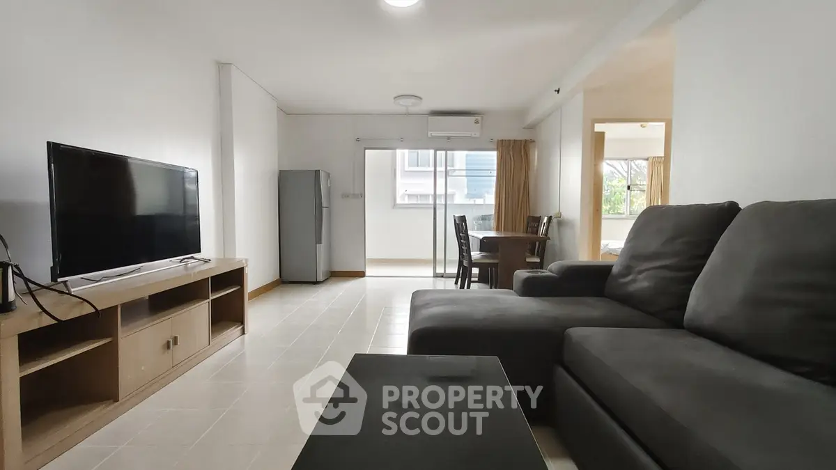Spacious living room with modern furniture and natural light in a stylish apartment.