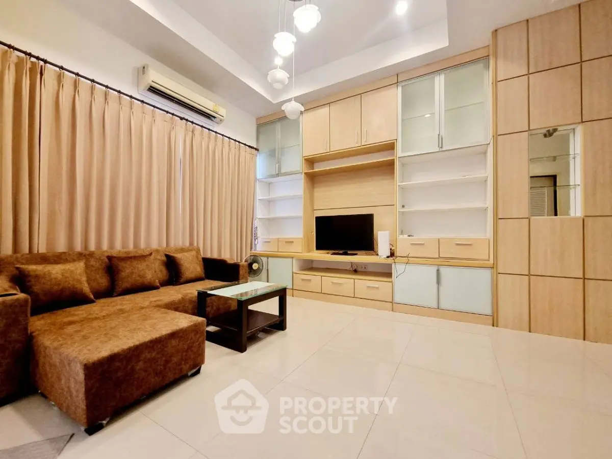 Spacious living room with modern furniture and built-in storage, perfect for family gatherings.