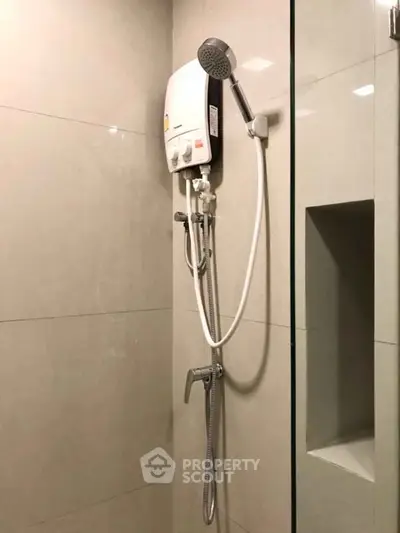 Modern bathroom with sleek shower and built-in storage niche.