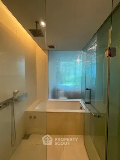 Luxurious modern bathroom with glass shower and bathtub in elegant apartment.