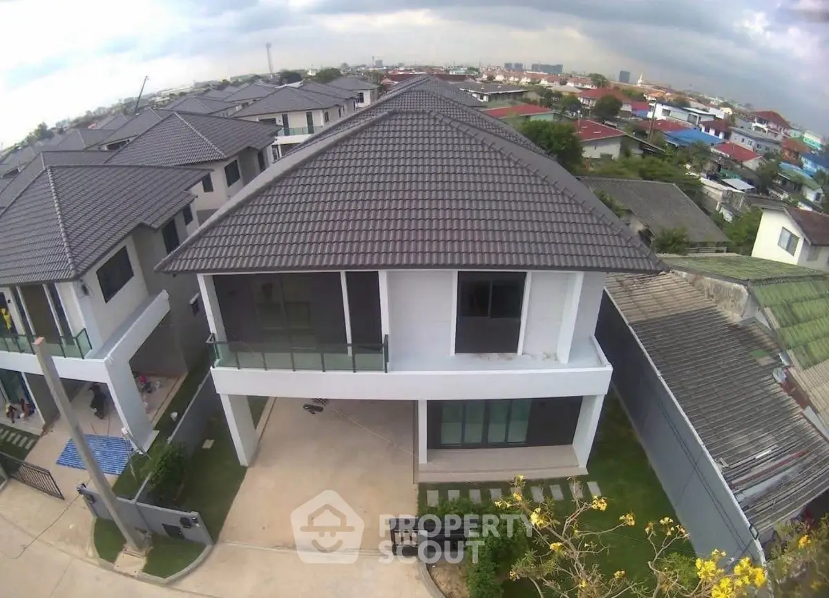 Modern two-story house with a tiled roof in a suburban neighborhood.
