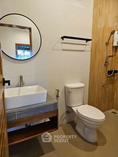 Modern bathroom with stylish round mirror and sleek fixtures