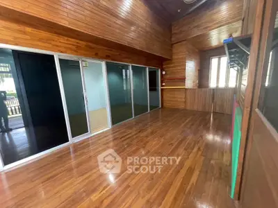 Spacious wooden interior with sliding glass doors and natural light, perfect for versatile living space.