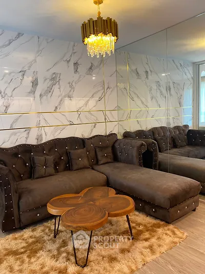 Luxurious living room with plush sofa, elegant chandelier, and stylish marble wall design.