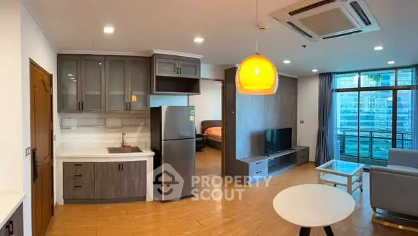 Modern open-plan living room with kitchen and balcony view