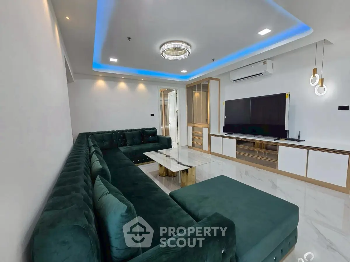 Luxurious modern living room with elegant green sectional sofa and sleek entertainment center.