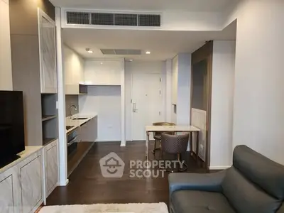 Modern open-plan living room with sleek kitchen and cozy seating area, perfect for urban living.