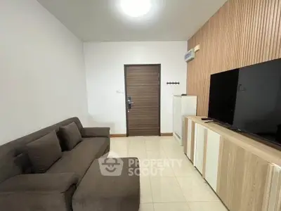 Modern living room with sleek furniture and large TV, perfect for relaxation.