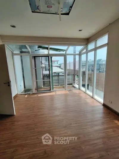 Spacious room with large windows offering abundant natural light and modern flooring.