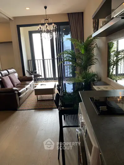 Modern living room with elegant decor, large windows, and open kitchen layout in a stylish apartment.