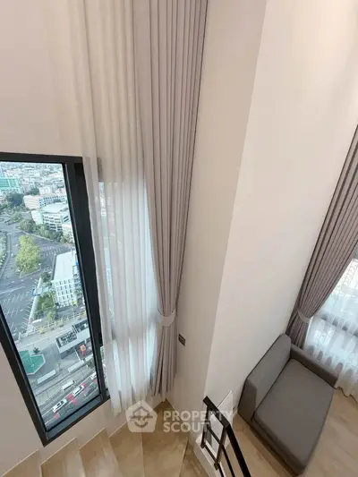 Modern duplex apartment with tall windows and city view
