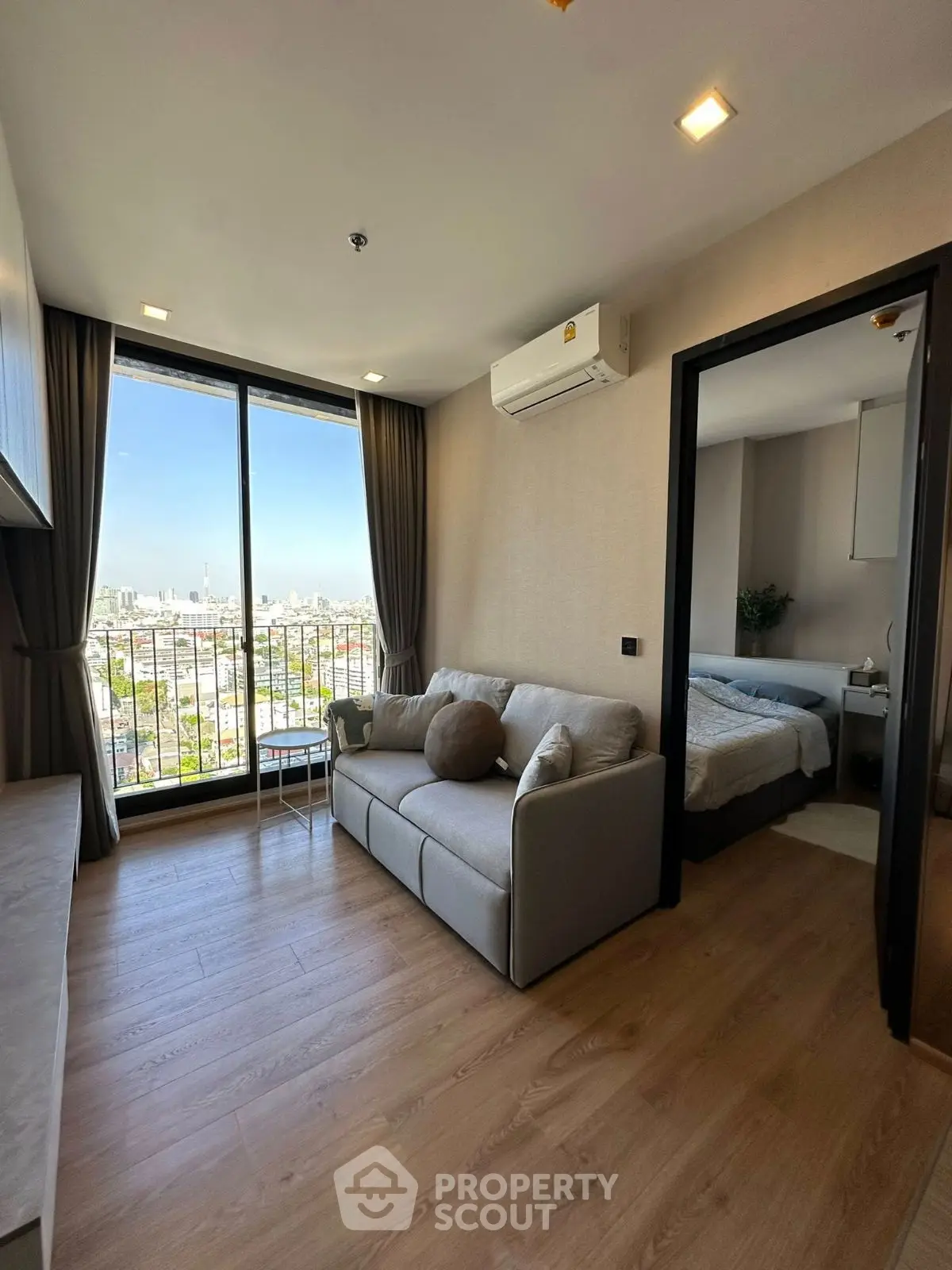 Modern living room with city view and cozy bedroom access