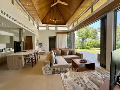 Luxurious open-plan living room with high wooden ceiling and garden view, perfect for modern living.