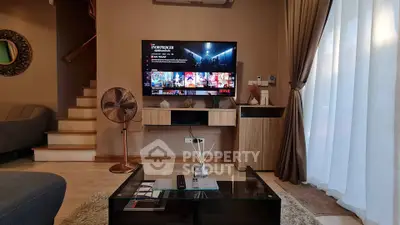 Modern living room with stylish decor, TV setup, and cozy ambiance perfect for relaxation.
