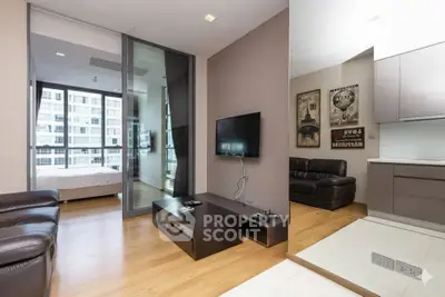 Modern living room with sleek design and view into a stylish bedroom in a high-rise apartment.