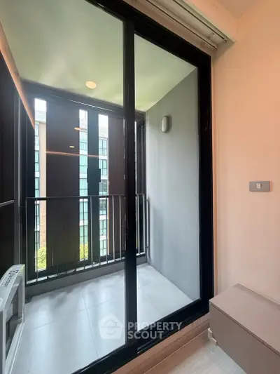 Modern apartment balcony with glass doors and city view