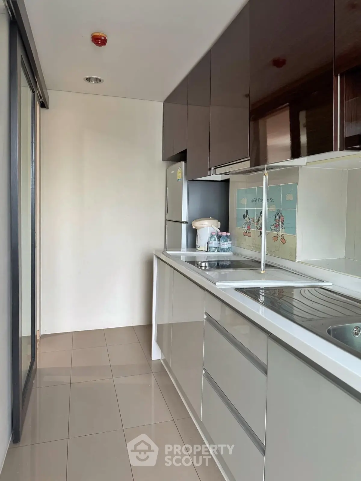 Modern kitchen with sleek cabinetry and stainless steel appliances in a contemporary apartment.