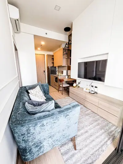 Modern living room with stylish furniture and open kitchen layout in a cozy apartment.