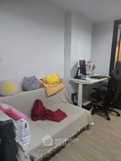 Cozy study area with desk, chair, and sofa in modern apartment