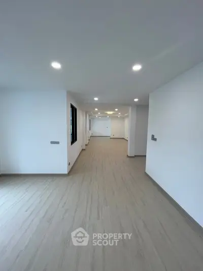 Spacious modern interior with sleek flooring and recessed lighting, ideal for versatile living arrangements.