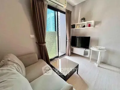 Modern living room with balcony view, featuring sleek furniture and stylish decor in a contemporary apartment.