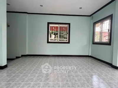 Spacious empty room with tiled floor and large windows, ideal for customization.