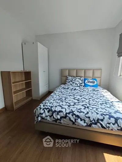 Cozy bedroom with stylish bed and ample natural light, perfect for relaxation.