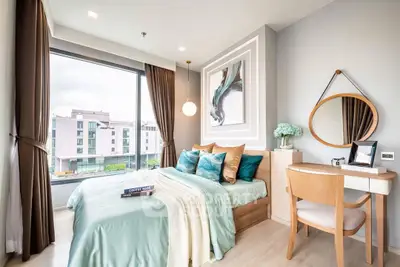 Modern bedroom with large window and stylish decor in a luxury apartment.