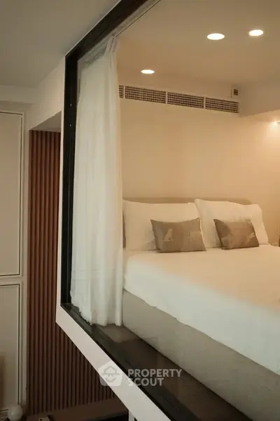 Modern bedroom with large window and elegant decor, showcasing a cozy and inviting atmosphere.