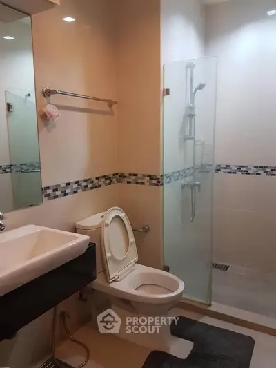 Modern bathroom with glass shower and sleek fixtures in a contemporary home.