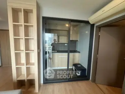 Modern apartment with enclosed kitchen and sleek wooden shelving, offering a compact yet stylish living space.