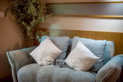 Cozy living room with plush sofa and decorative pillows, perfect for relaxation.